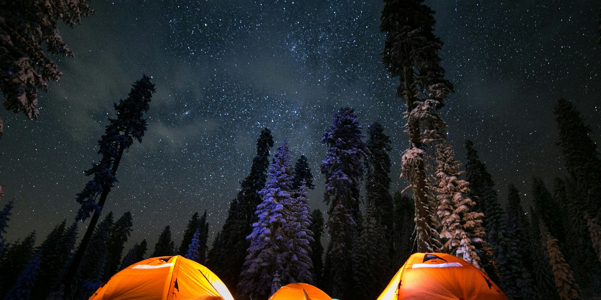 Three tents pitched under a starry sky