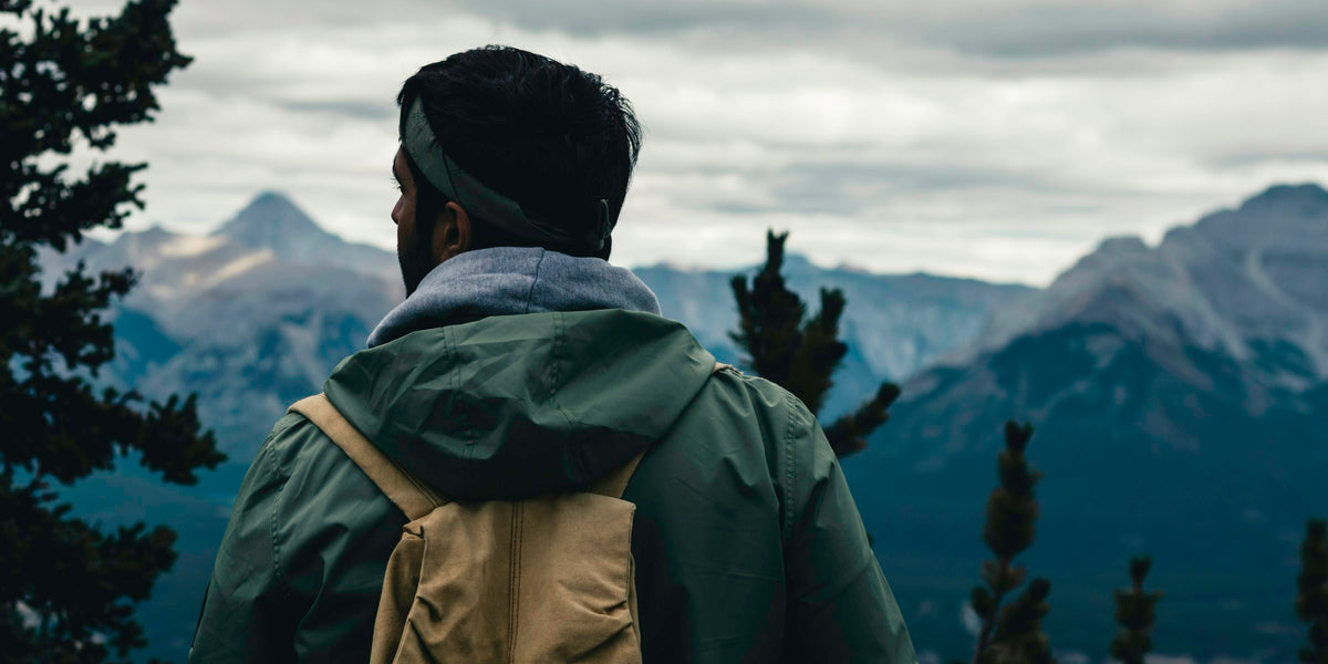 Hiker with a backpack looking towards the mountains