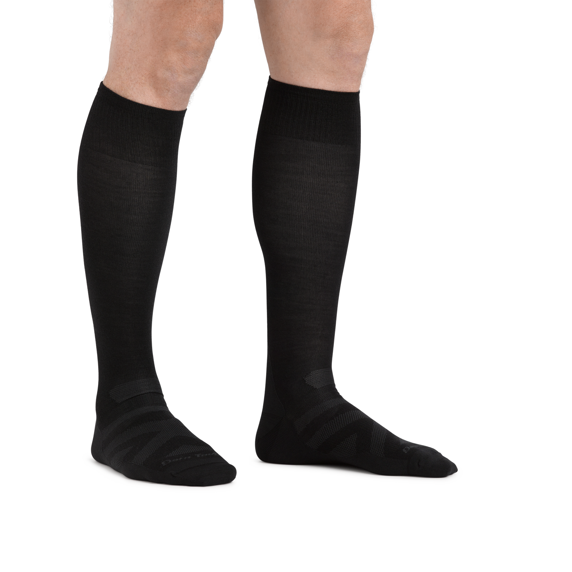Man standing barefoot wearing the Darn Tough RFL Over-the-Calf Ultra-Lightweight Ski & Snowboard Sock in Black