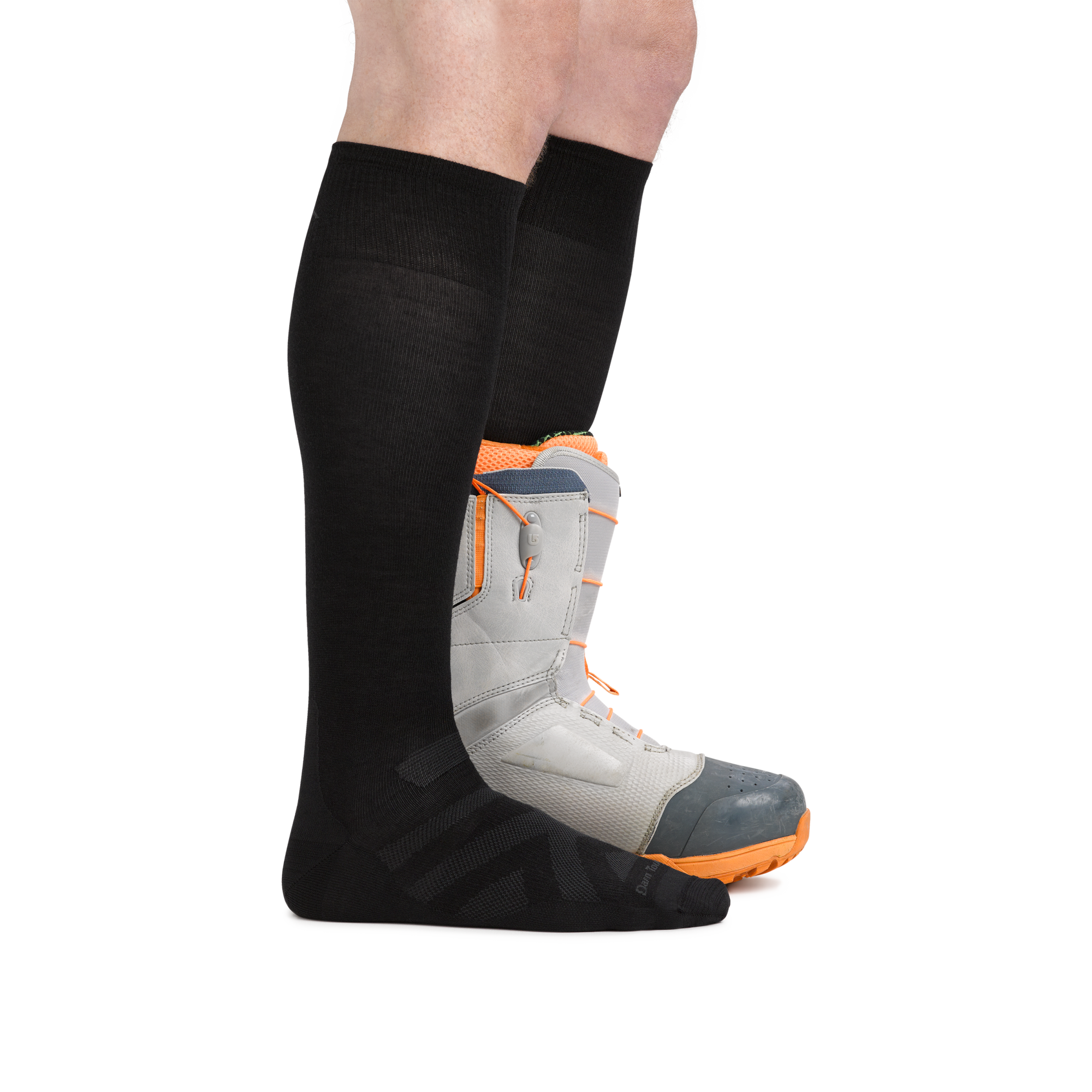Man wearing the Darn Tough RFL Over-the-Calf Ultra-Lightweight sock in Black with the back foot in a snowboard boot